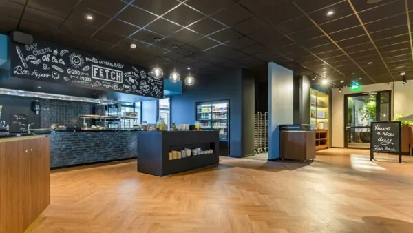 Modern bedrijfsrestaurant aan de George Hintzenweg met zelfbedieningsbuffet, vrolijke krijtborddecoratie en een uitnodigende sfeer.